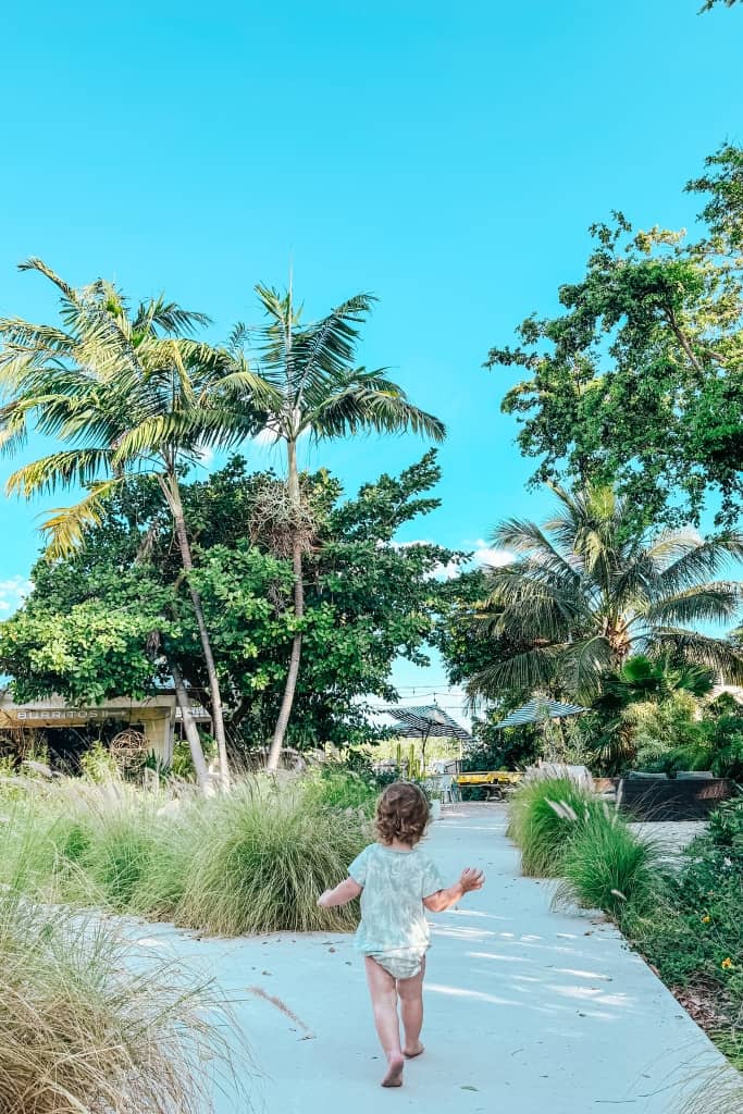 little boy running barefoot on the sidewalk at the trading post in islamorada
